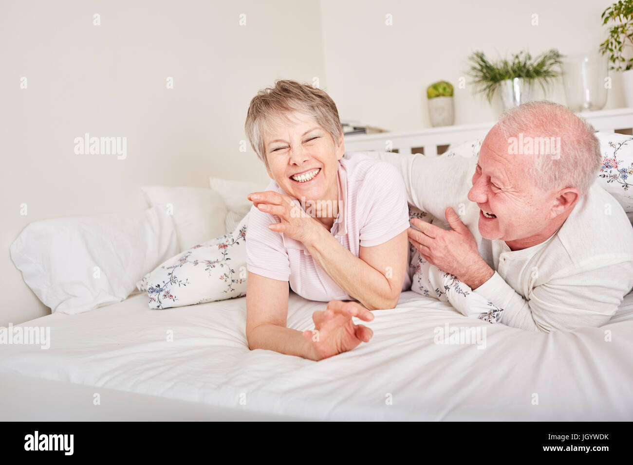 Coppia senior divertirsi nella camera da letto di ridere su sciocchezze Foto Stock
