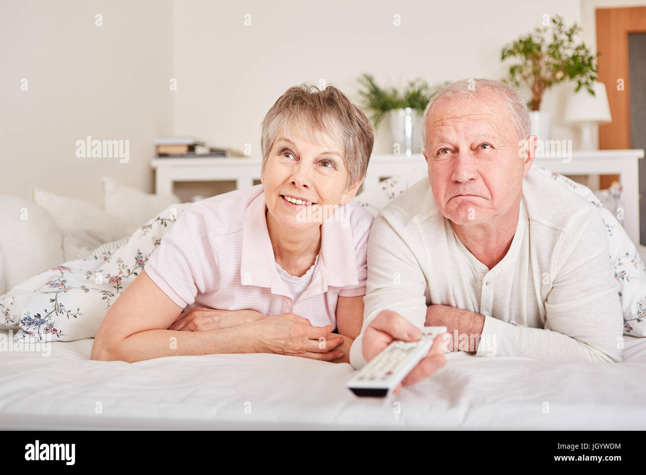I cittadini anziani guardare la TV a letto per intrattenimento Foto Stock