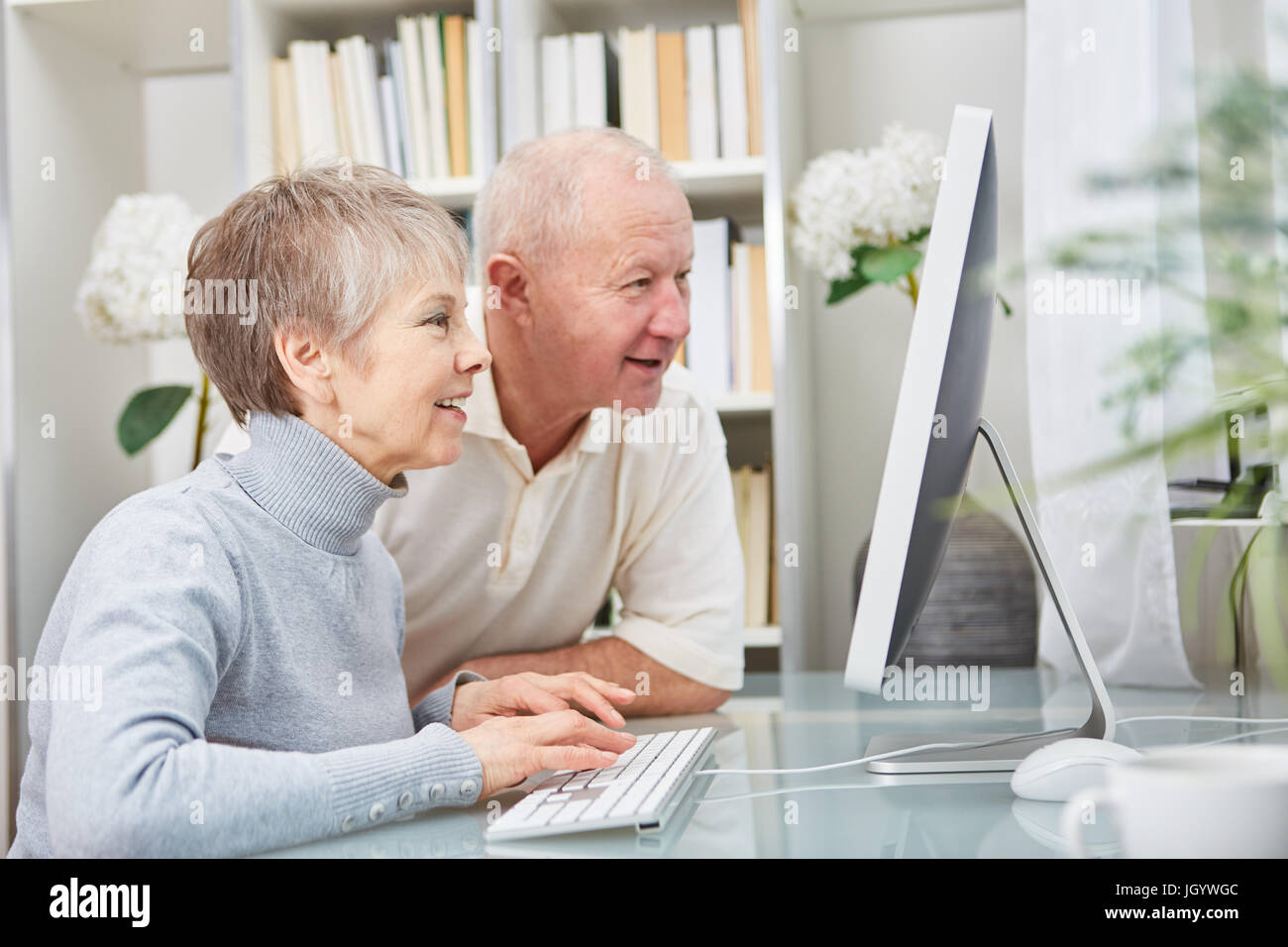 I cittadini anziani guardare PC con curiosità e imparare circa il cyberspazio Foto Stock