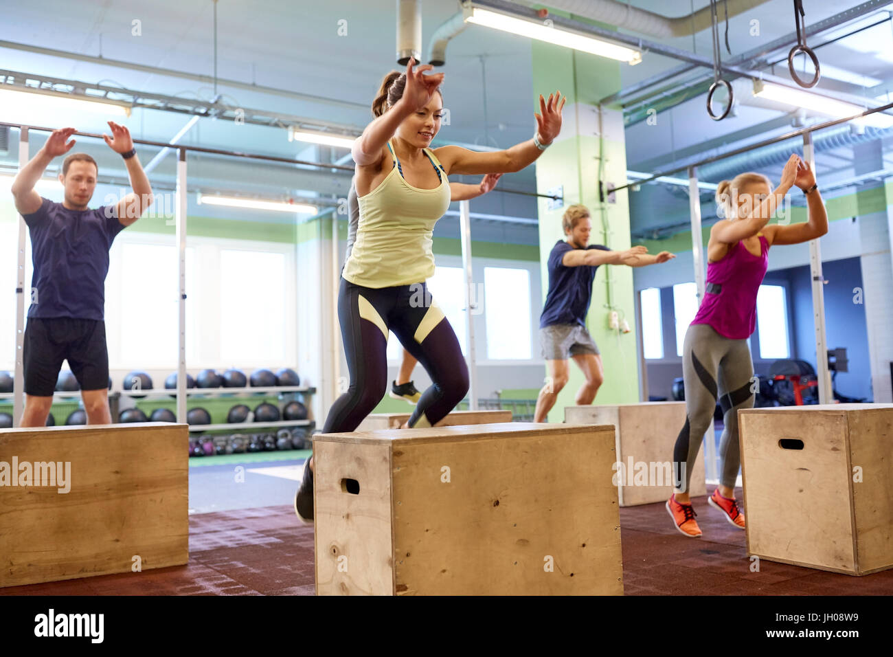 Gruppo di persone facendo salti di scatola di esercizio in palestra Foto Stock