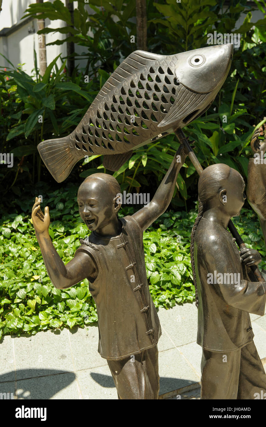 La scultura raffigurante i bambini in una processione cinesi in Telok Ayer verde, Chinatown, Singapore Foto Stock