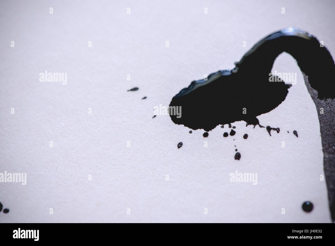 Un splotch di inchiostro nero su carta bianca Foto Stock