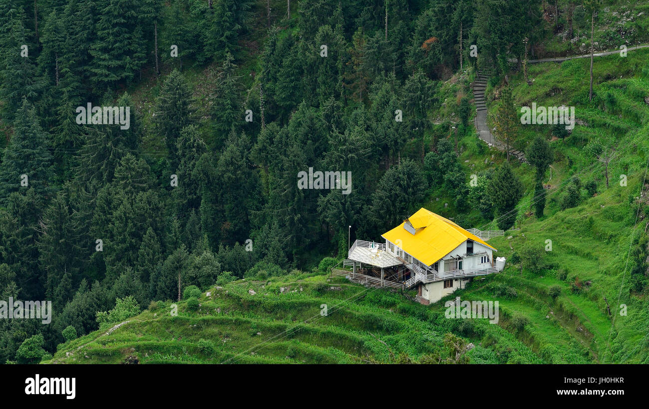 Casa con tetto di colore giallo nel mezzo delle montagne Foto Stock