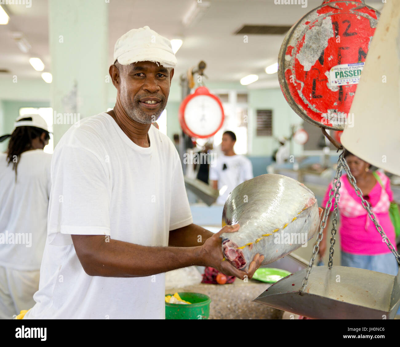 Un pescivendolo locale da Kingstown, Saint Vincent e Grenadine nei Caraibi pone con un grosso taglio di tonno Foto Stock