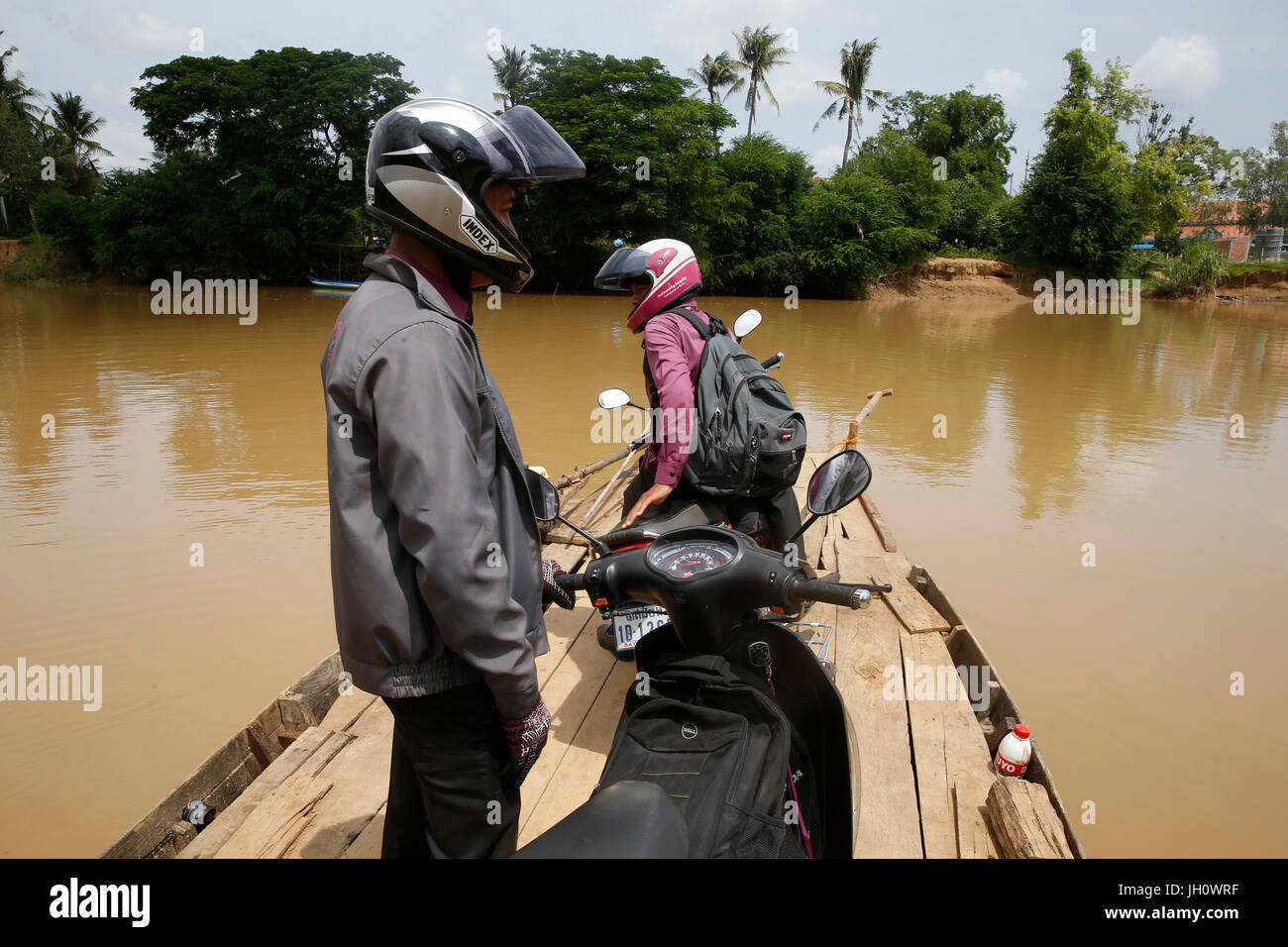 AMK microfinanziamenti dipendenti attraversando il fiume Sangke per visitare i clienti. Cambogia. Foto Stock
