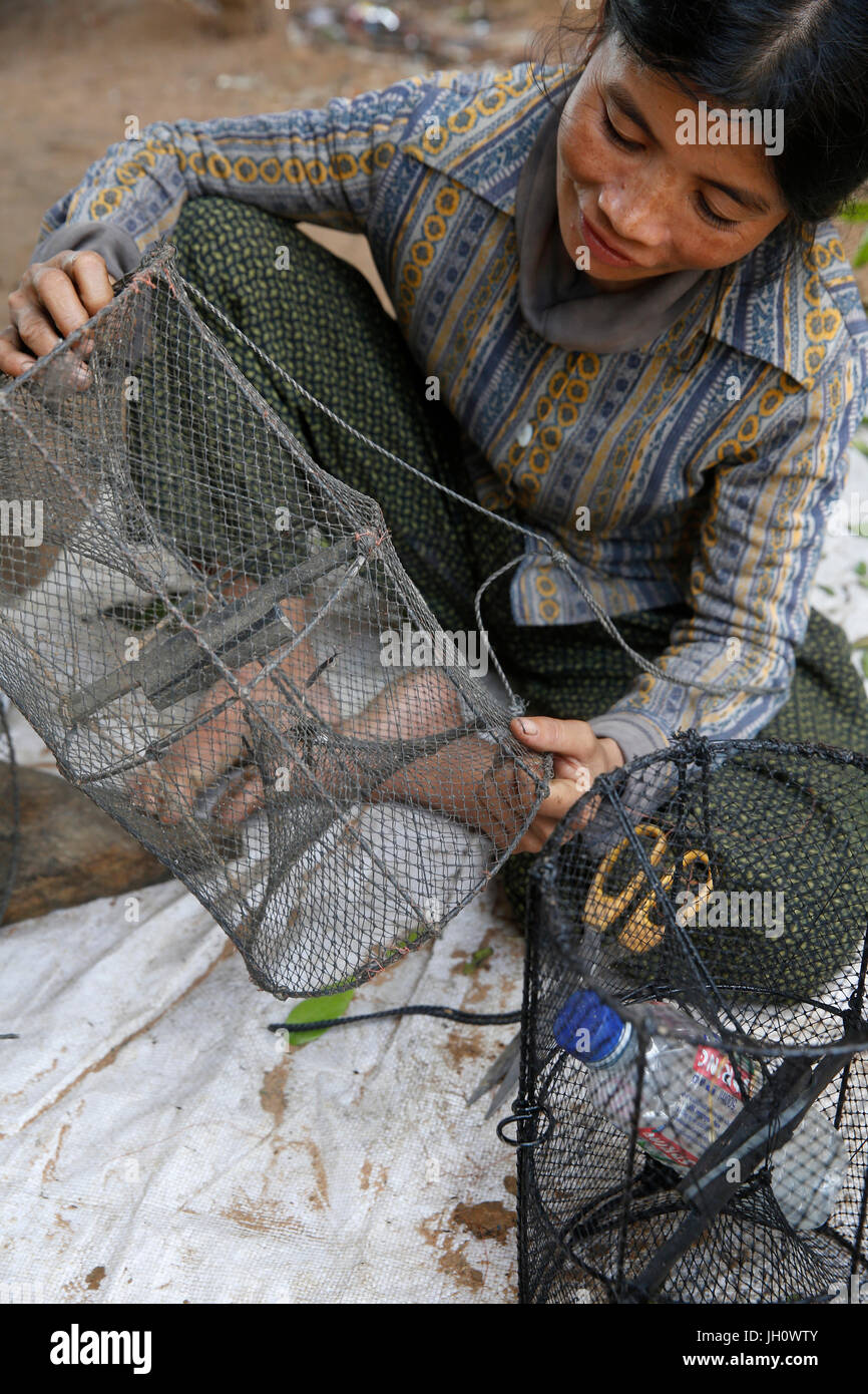 AMK client di microfinanza Lina partita la riparazione di attrezzature da pesca. Cambogia. Foto Stock