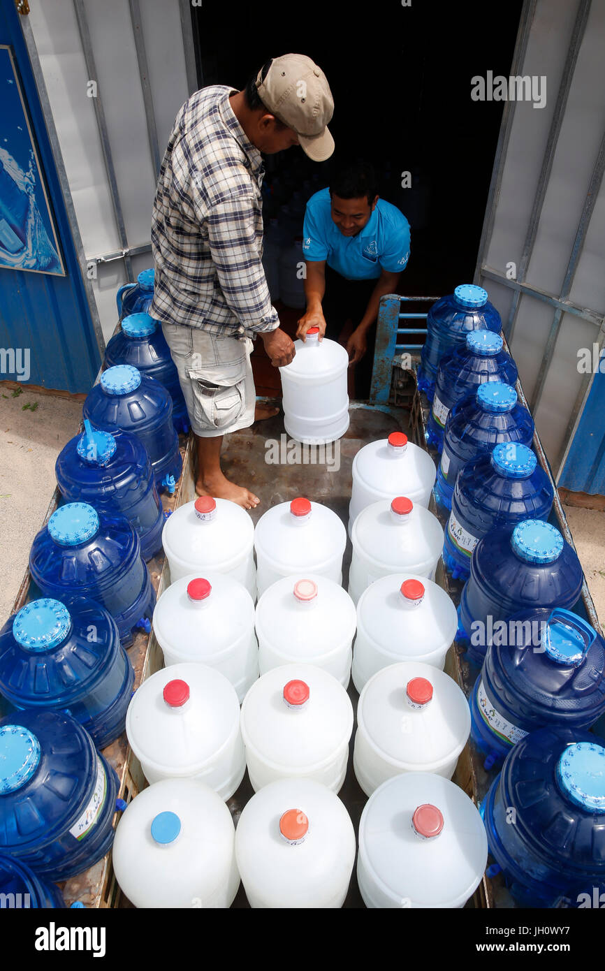 1001 Fontane di acqua ai dipendenti della società il riempimento di un carrello per la consegna. Cambogia. Foto Stock