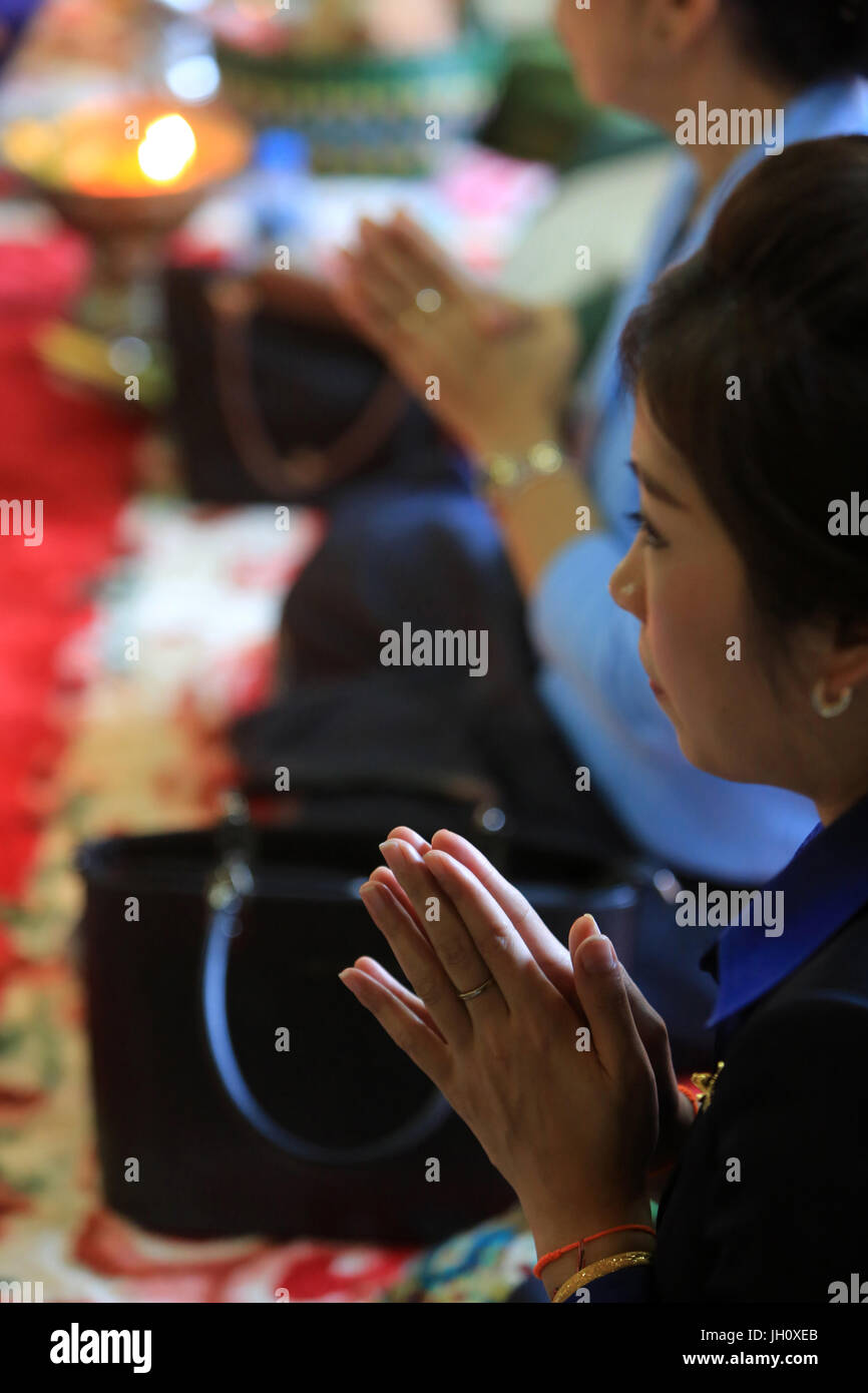 Donna che prega. Cerimonia buddista. Wat Si Muang. Vientiane. Foto Stock