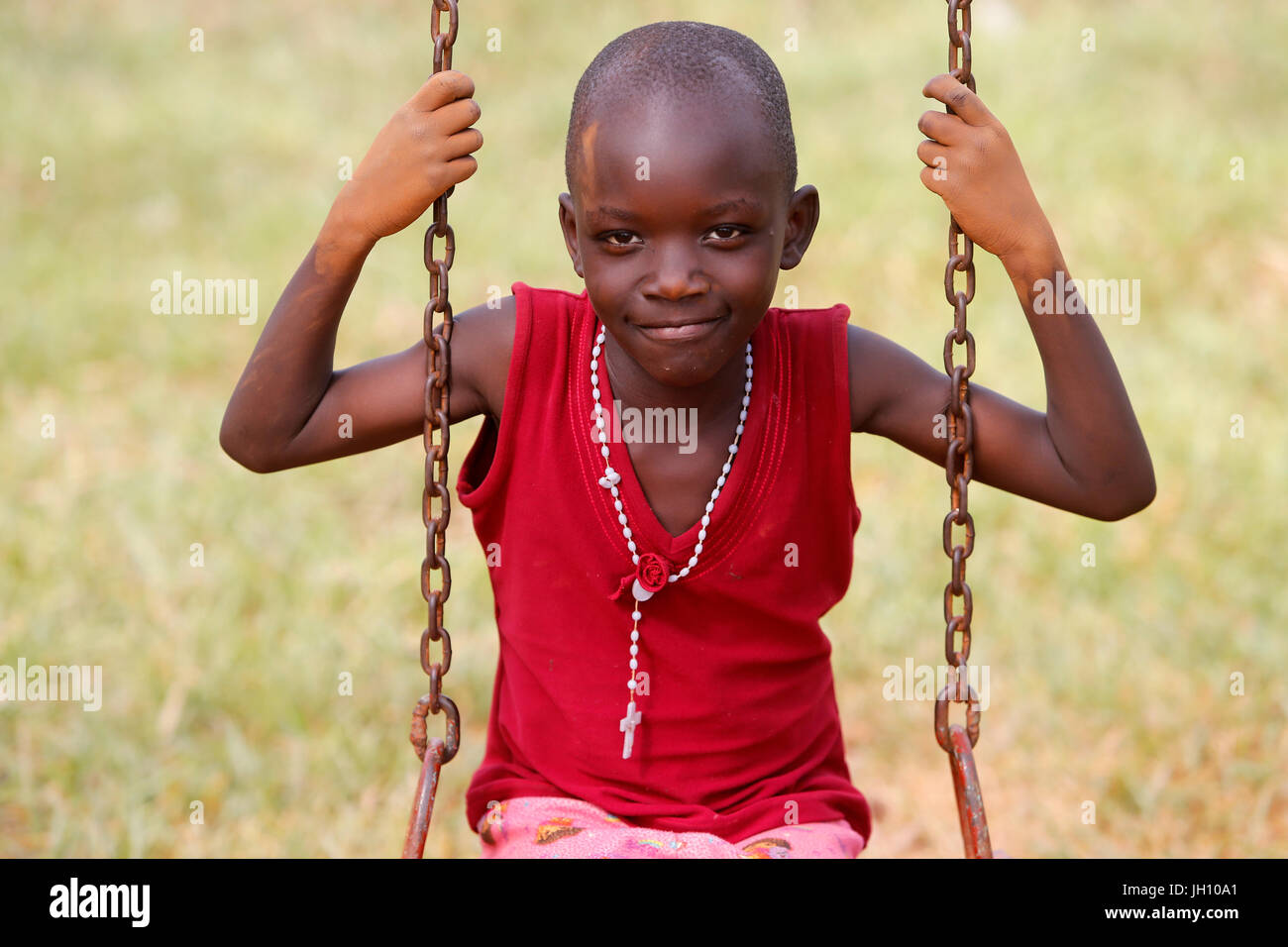 Bambino ugandese su altalena. Uganda. Foto Stock