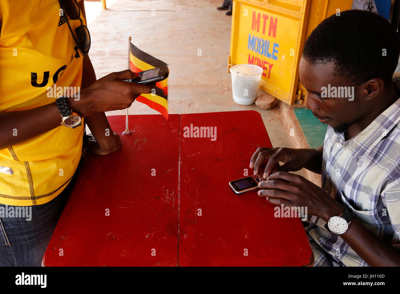 Donna ugandese di inviare denaro tramite il telefono cellulare. Uganda. Foto Stock