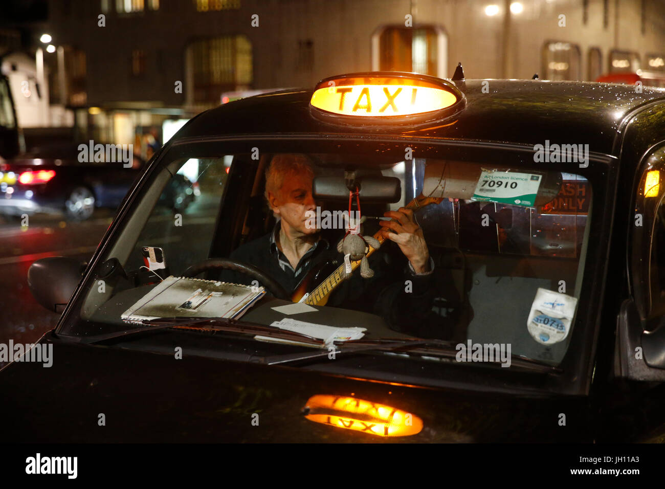 Londra tassista praticando la sua chitarra. Regno Unito. Foto Stock