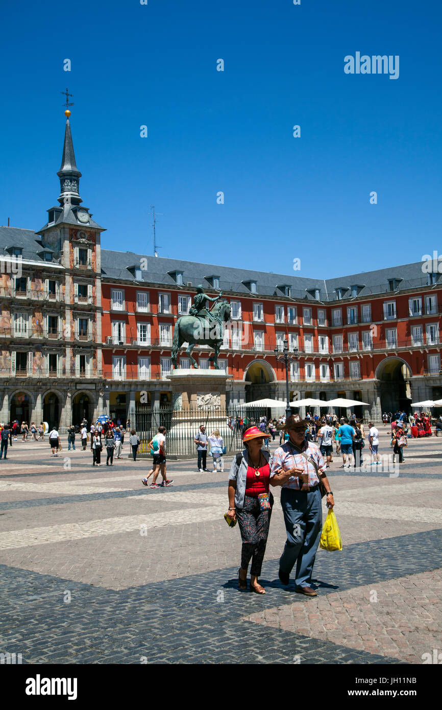 Per i turisti a piedi nella Plaza Mayor Madrid sotto cieli azzurri Foto Stock