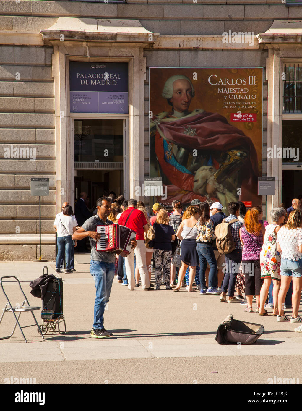 L'uomo suonare la fisarmonica a piano per divertire la gente in coda per entrare al Royal Palace/ Palacio Real a Madrid Spagna Foto Stock