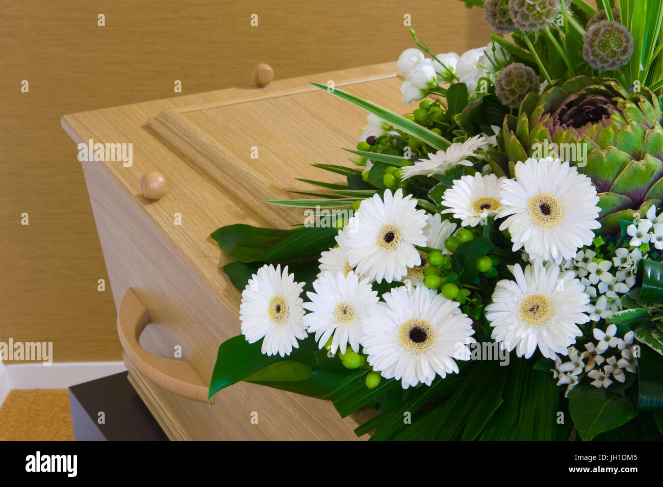 Una bara con un omaggio floreale in un obitorio Foto Stock