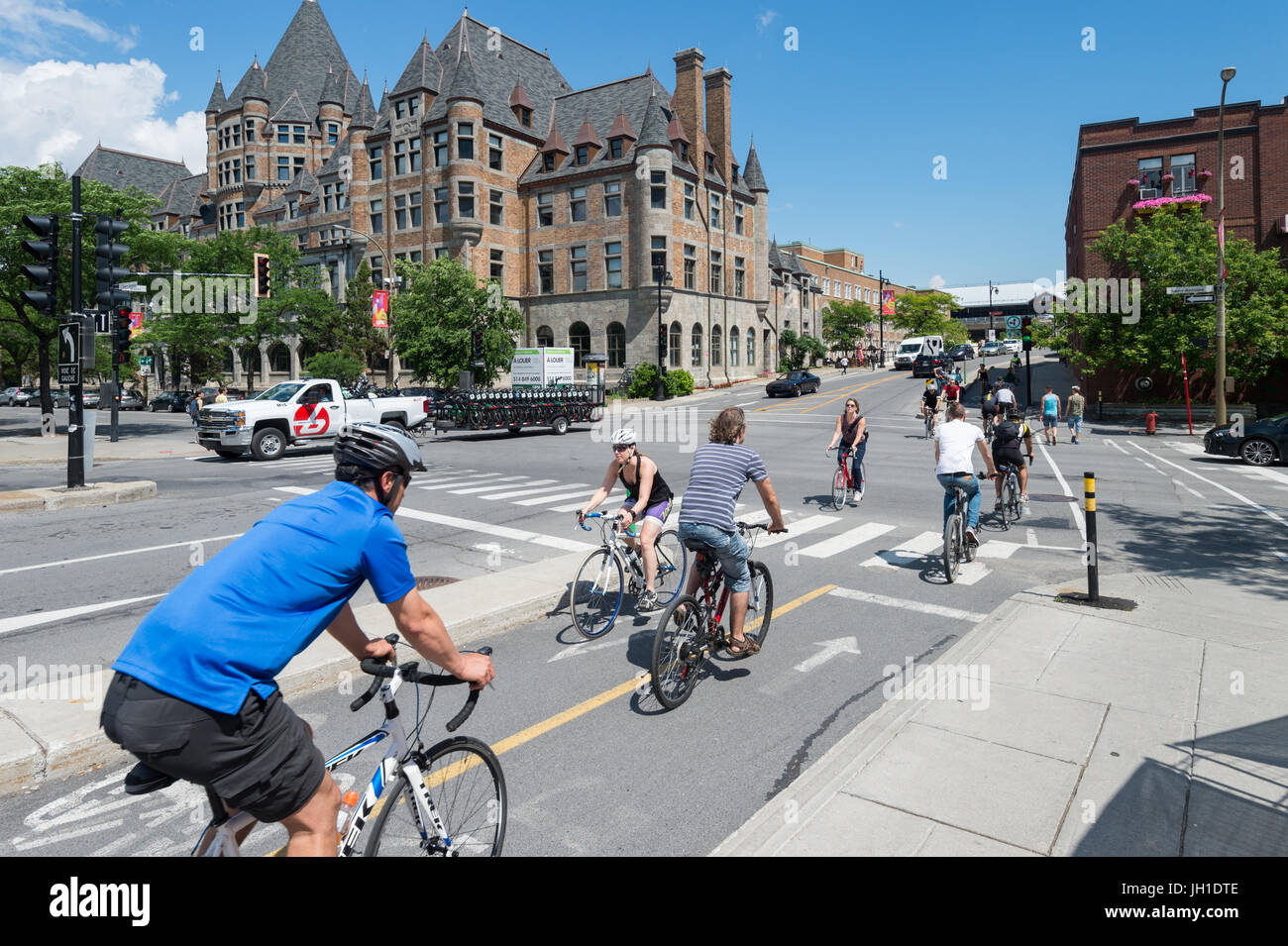 Gente in bicicletta nel Vecchio Porto di Montreal, con gare Viger edificio in background (luglio 2017) Foto Stock