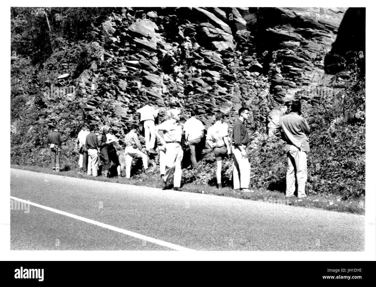 Illustri geologo Ernst Cloos e studenti nella sua classe campo alla Johns Hopkins University esamina le formazioni rocciose accanto a una strada, 1955. Foto Stock