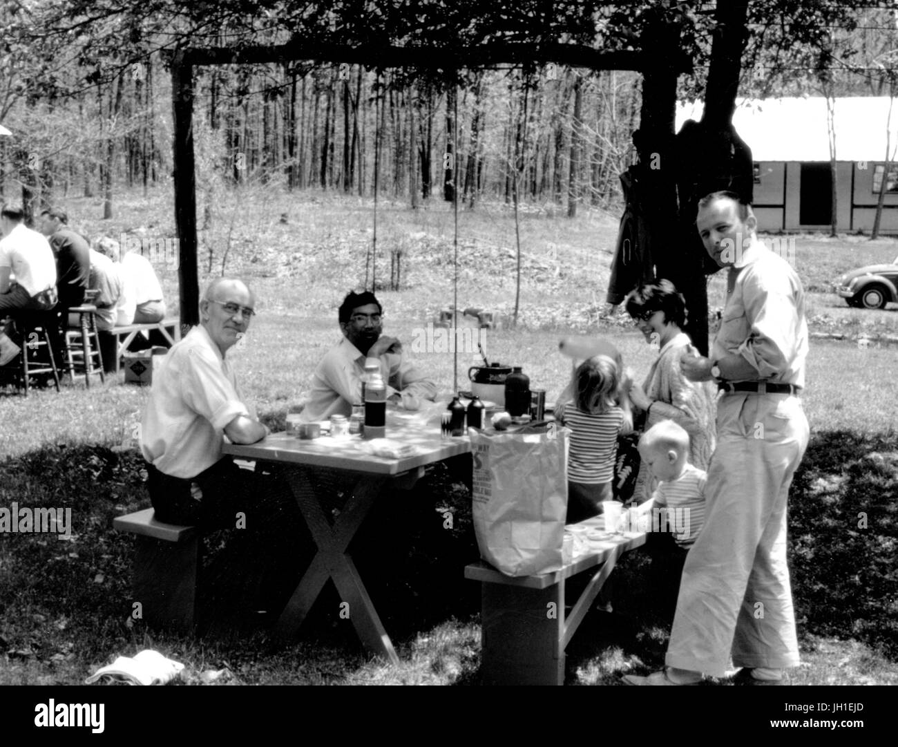 Gli uomini seduti attorno a un tavolo da picnic con i loro figli durante una geologia fieldtrip per Johns Hopkins University, 1970. Foto Stock