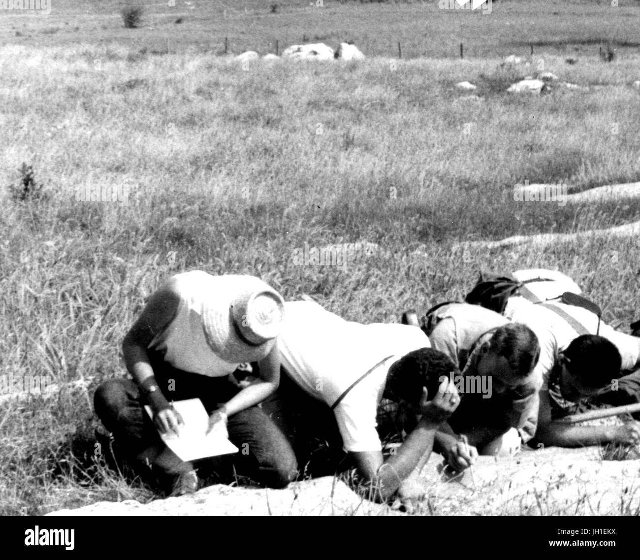Gli studenti della Johns Hopkins Geologia inginocchiato sul campo e di esaminare il terreno e a prendere nota delle loro osservazioni, 1975. Foto Stock