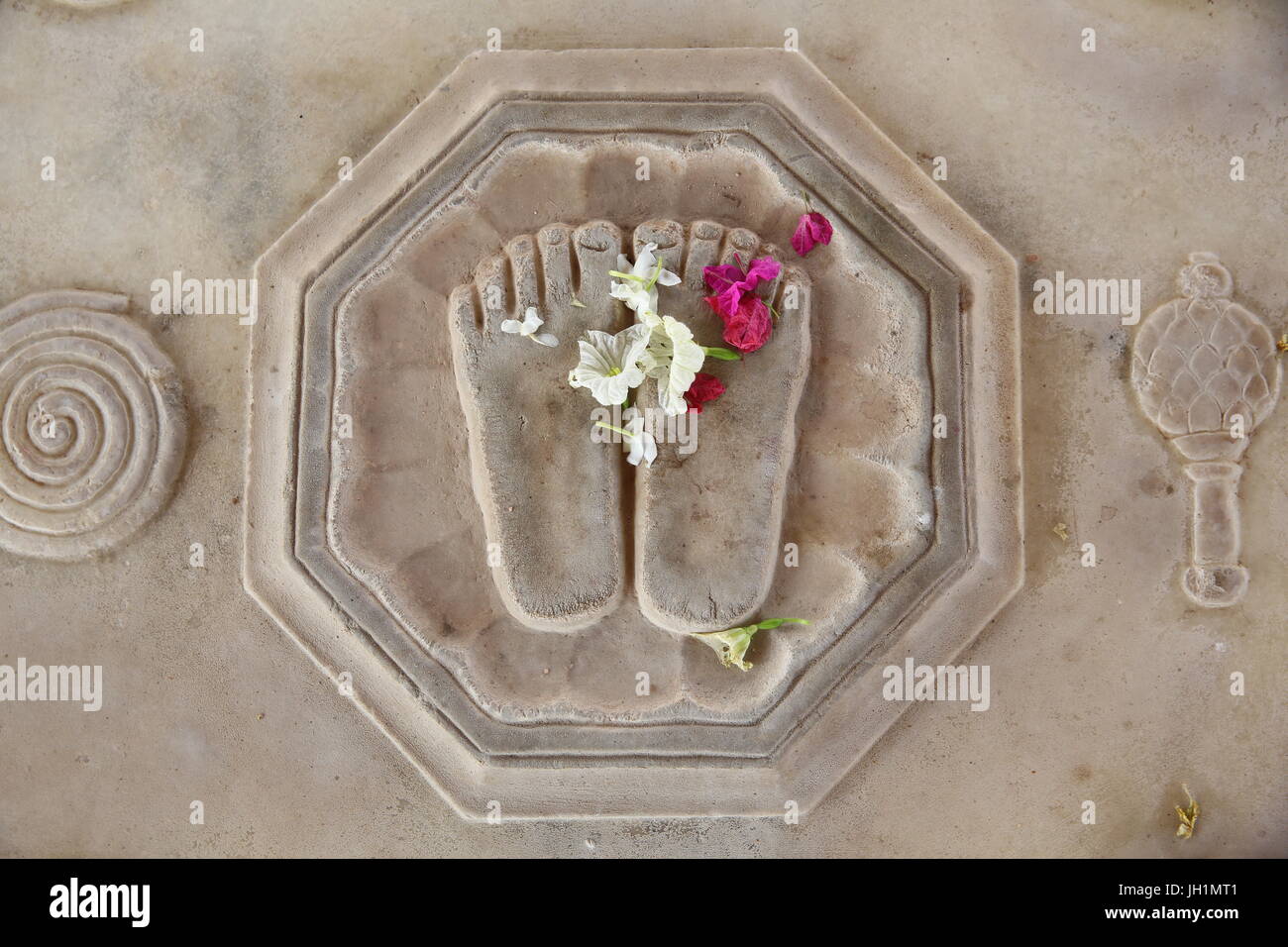 Fiore che offre su Krishna la lotus piedi incisa sul pavimento in Kusum Sarovar. India. Foto Stock