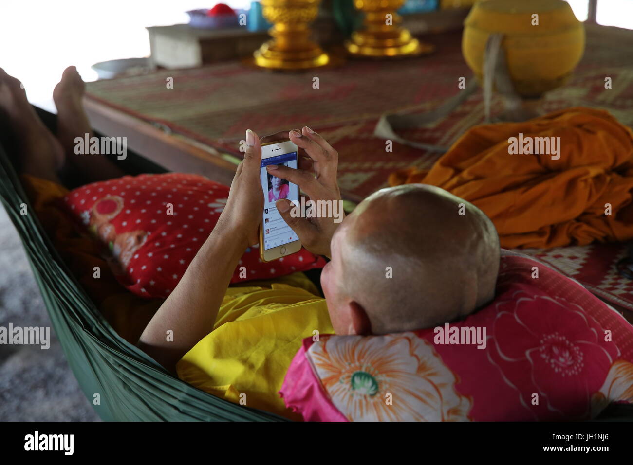 Monaco utilizzando un telefono cellulare. Cambogia. Foto Stock