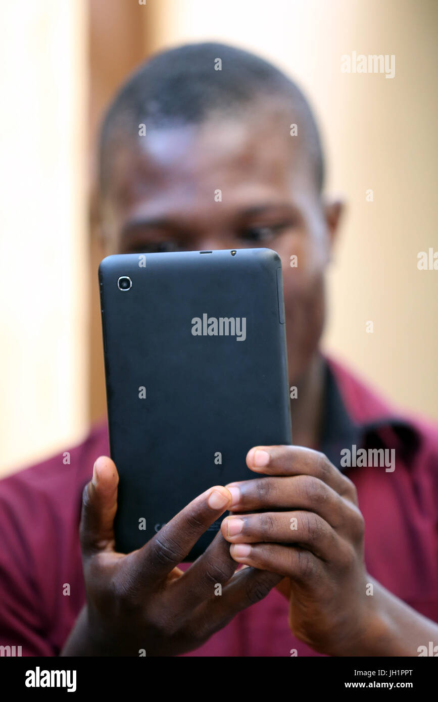 L'uomo africano utilizzando un telefono intelligente. Lomé. Il Togo. Foto Stock