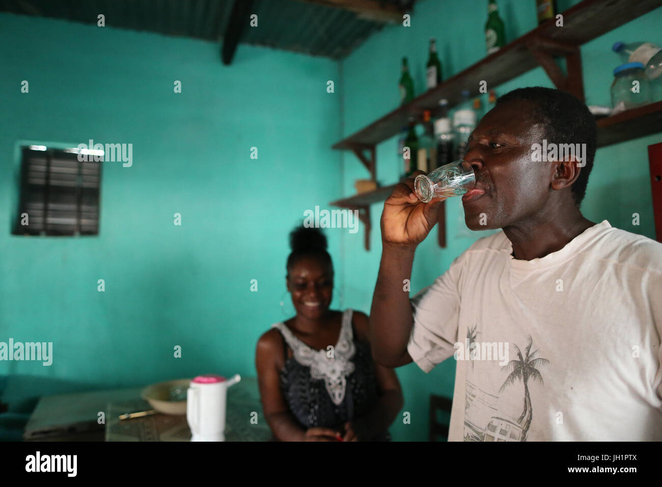 Uomo di bere alcol di palma in un bicchiere. Lomé. Il Togo. Foto Stock