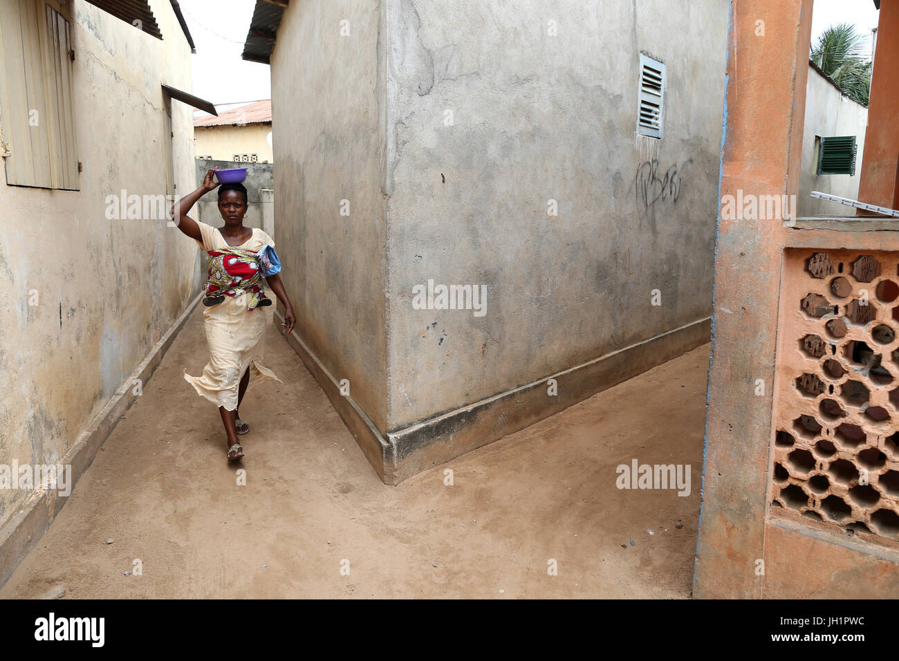 Donna africana a camminare in un vicolo. Lomé. Il Togo. Foto Stock