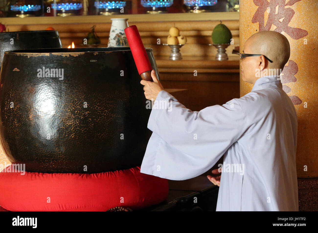 Quan l'Am Bo Tat tempio (Pagoda di Avalokitesvara Bodhisattva). Il vietnamita monaca buddista utilizzando un gigante Singing Bowl. Vung Tau. Il Vietnam. Foto Stock