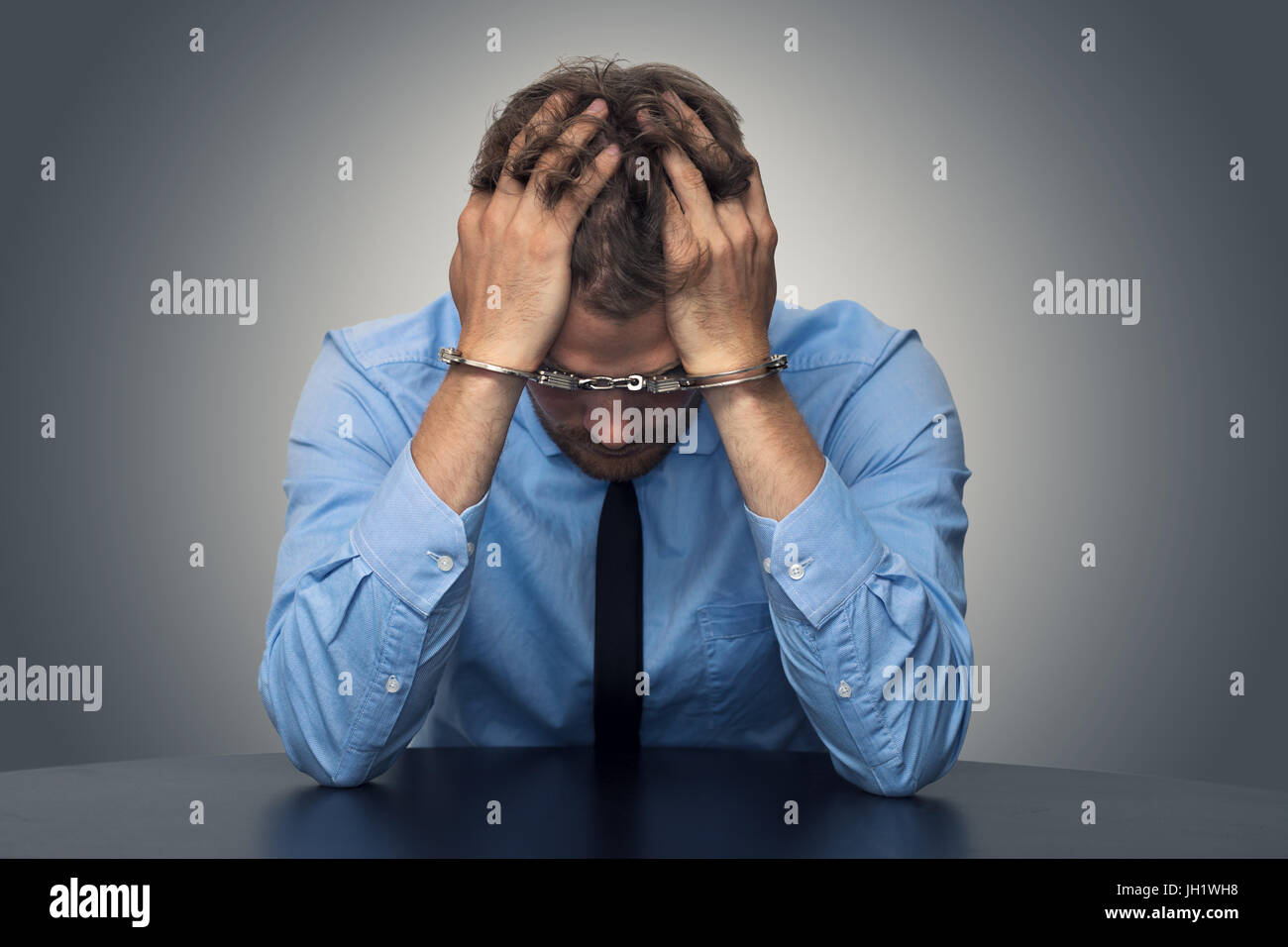 White Collar Crime concetto - disperato imprenditore con manette Foto Stock