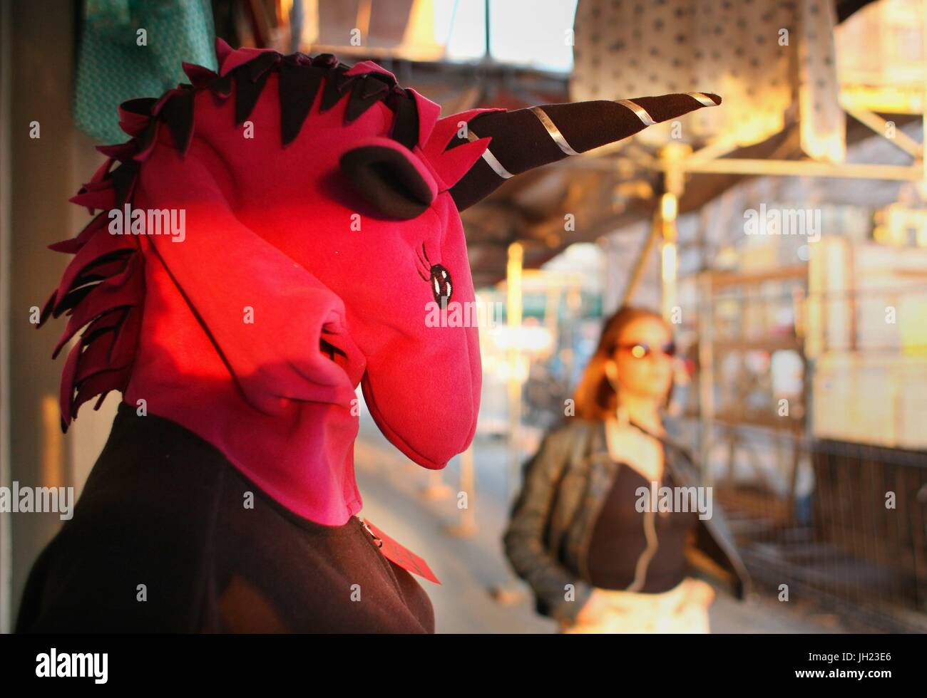 Una femmina di turisti a piedi da un manichino di visualizzazione che indossa una maschera unicorno davanti a un negozio a Berlino in Prenzlauer Berg area su Marzo 28, 2017. Questa immagine è parte di una serie di foto sul turismo a Berlino. Foto: Wolfram Steinberg/dpa | Utilizzo di tutto il mondo Foto Stock