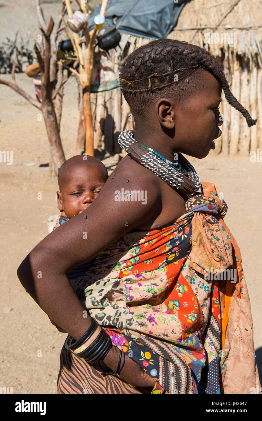 Ragazza Himba trasporta un bambino, Kaokoland, Namibia, Africa Foto Stock