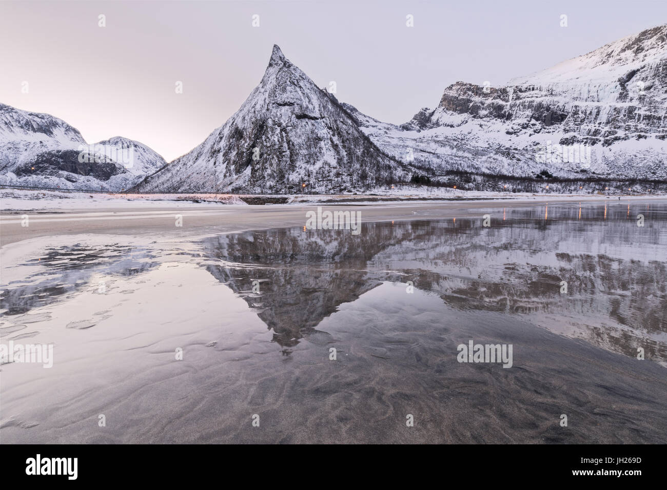 Vette innevate si riflette nel mare ghiacciato circondato dalla spiaggia sabbiosa di Alba, Ersfjord, Senja, Troms, Norvegia, Scandinavia, Europa Foto Stock