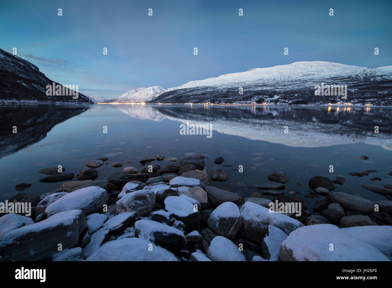 Vette innevate si riflette nel mare freddo al tramonto, Manndalen, Kafjord, Alpi Lyngen, Troms, Norvegia, Scandinavia, Europa Foto Stock