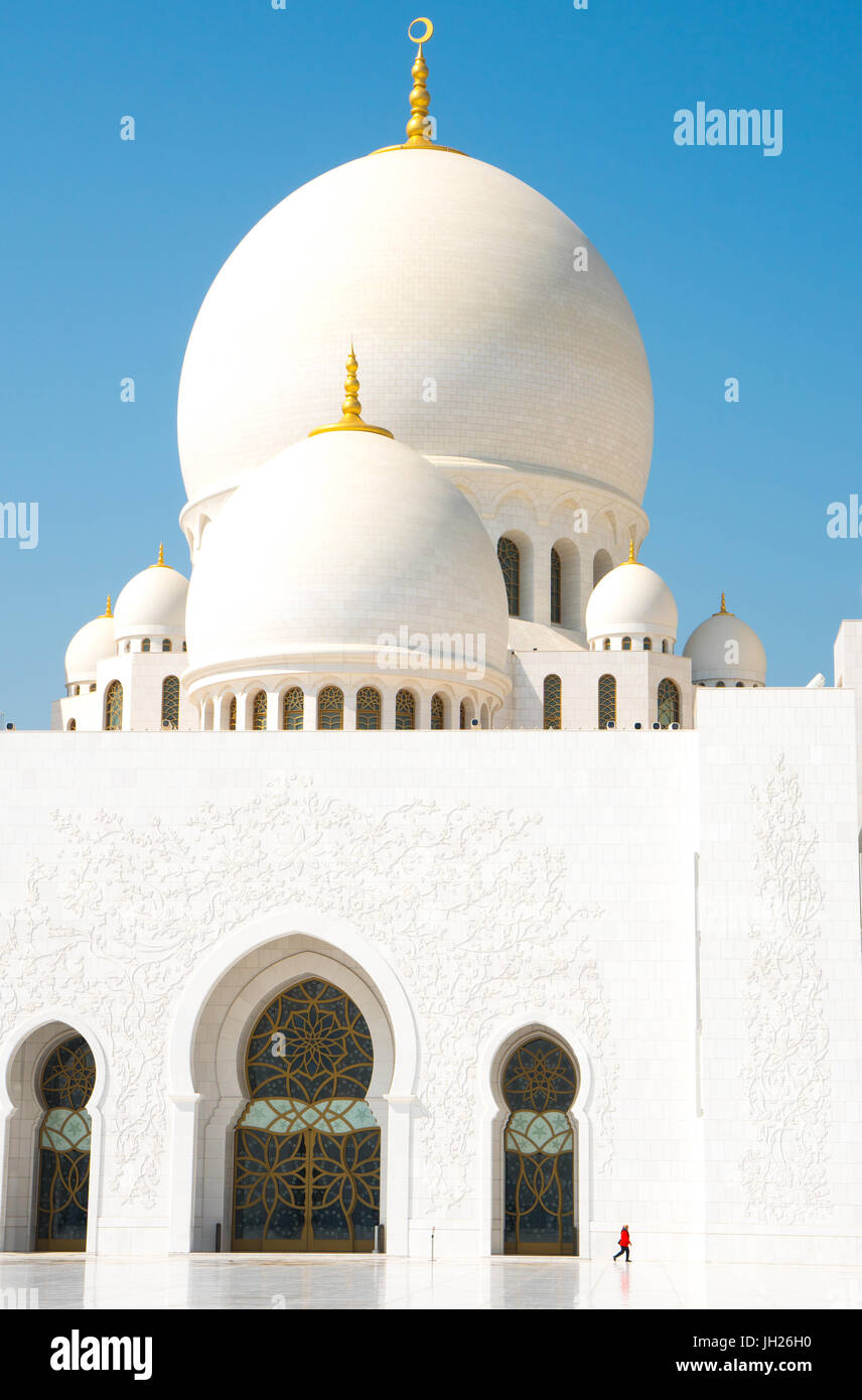 Interno della Sheikh Zayed Grande Moschea, edifici di marmo punteggiato da piccoli woman in red, Abu Dhabi, Emirati Arabi Uniti Foto Stock