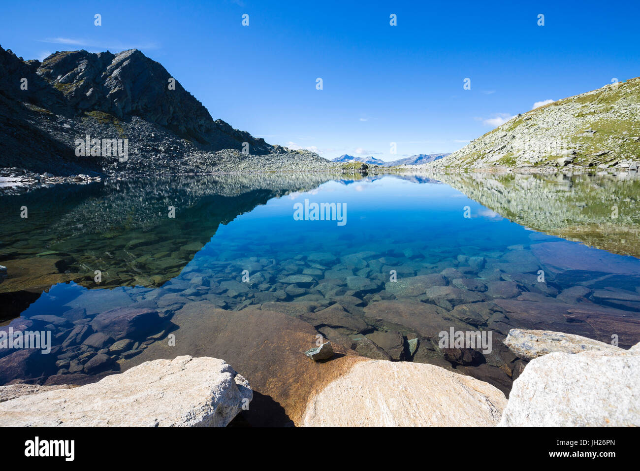 Cielo blu e picchi rocciosi riflessa nell'azzurro Lago Nero, Val Chiavenna, Valtellina, Lombardia, Italia, Europa Foto Stock