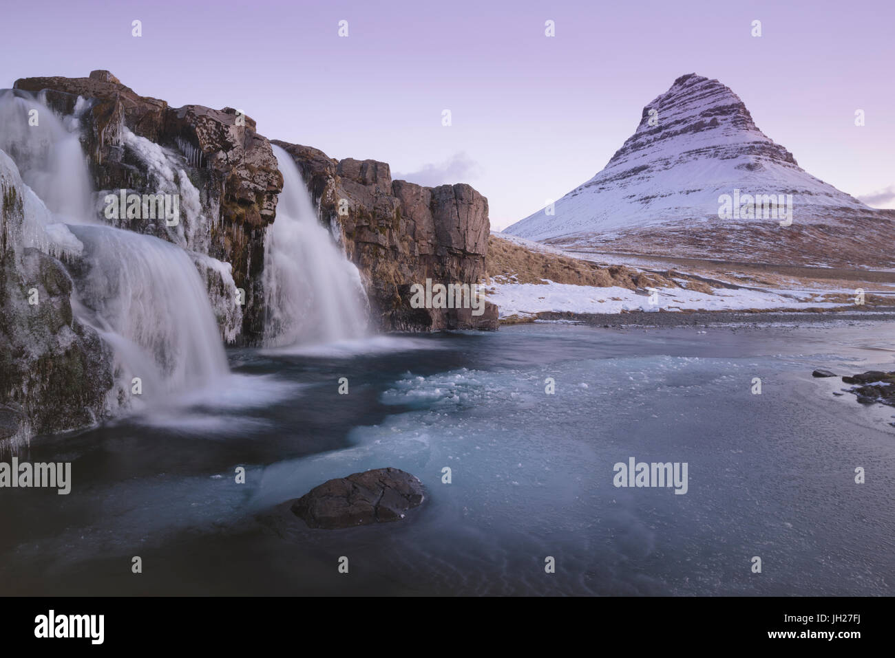 Sunrise a Kirkjufellsfoss e Kirkjufell montagna, Snaefellsnes Peninsula, Islanda, regioni polari Foto Stock