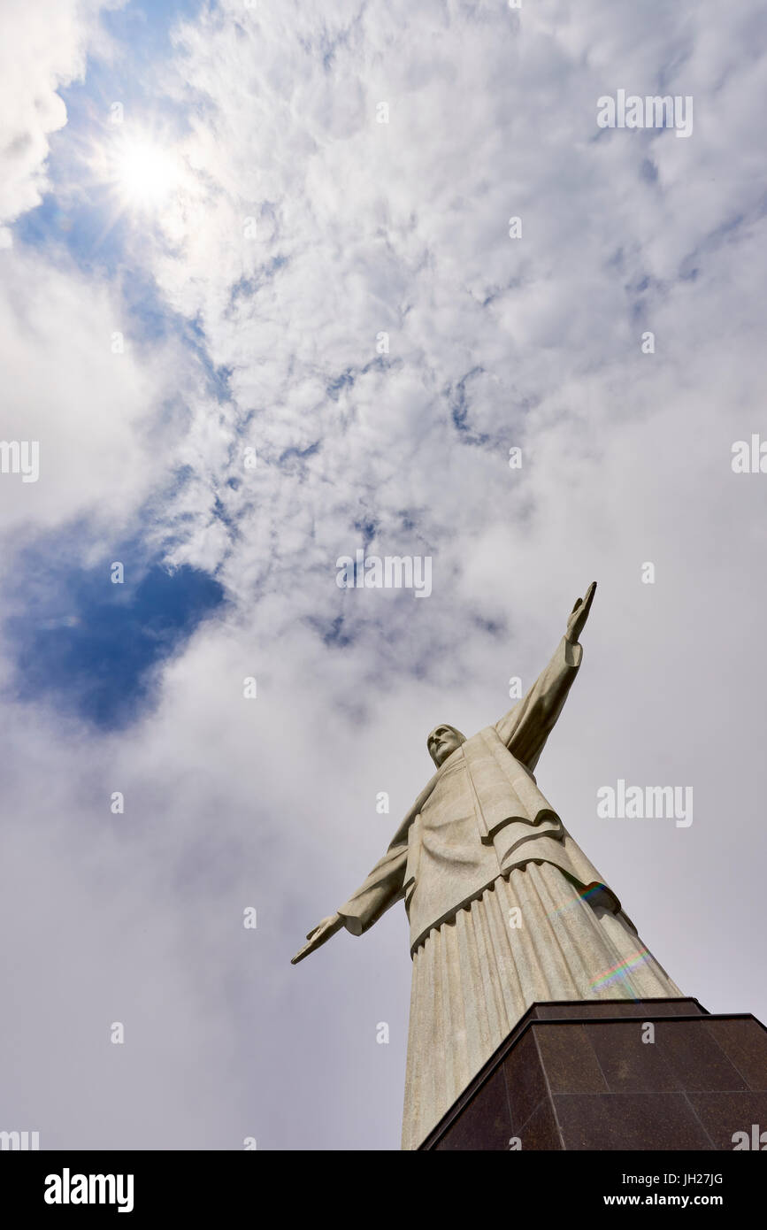 Bassa angolazione dell'iconica statua del Cristo Redentore con il sole che splende attraverso le nuvole, Rio de Janeiro, Brasile Foto Stock