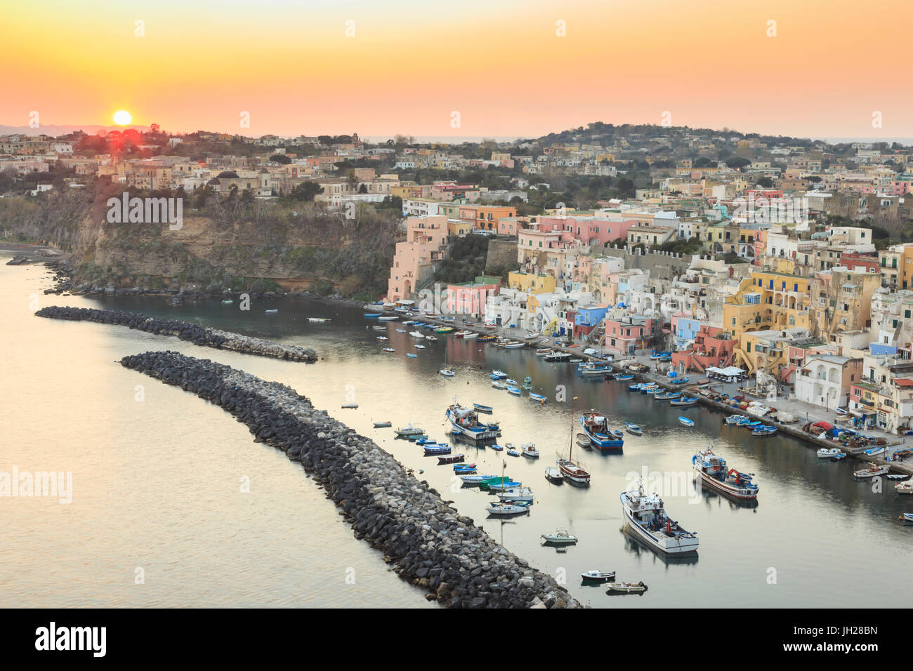 Marina Corricella tramonto, villaggio di pescatori, colorate case di pescatori, barche e chiesa, Isola di Procida e della baia di Napoli, Italia Foto Stock