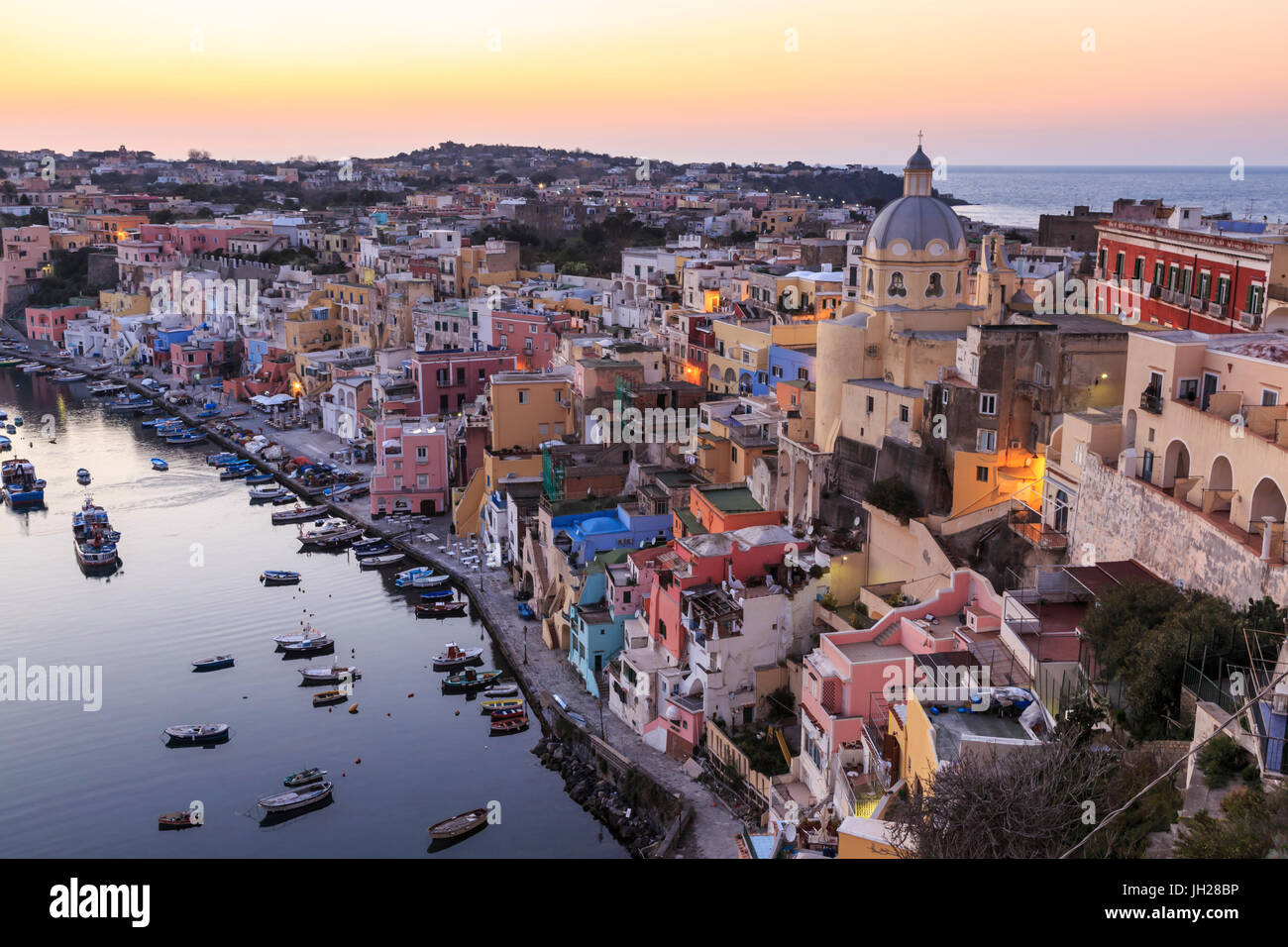 Marina Corricella, blu ora dopo il tramonto, villaggio di pescatori, case colorate, barche e chiesa, Procida, Baia di Napoli, Italia Foto Stock