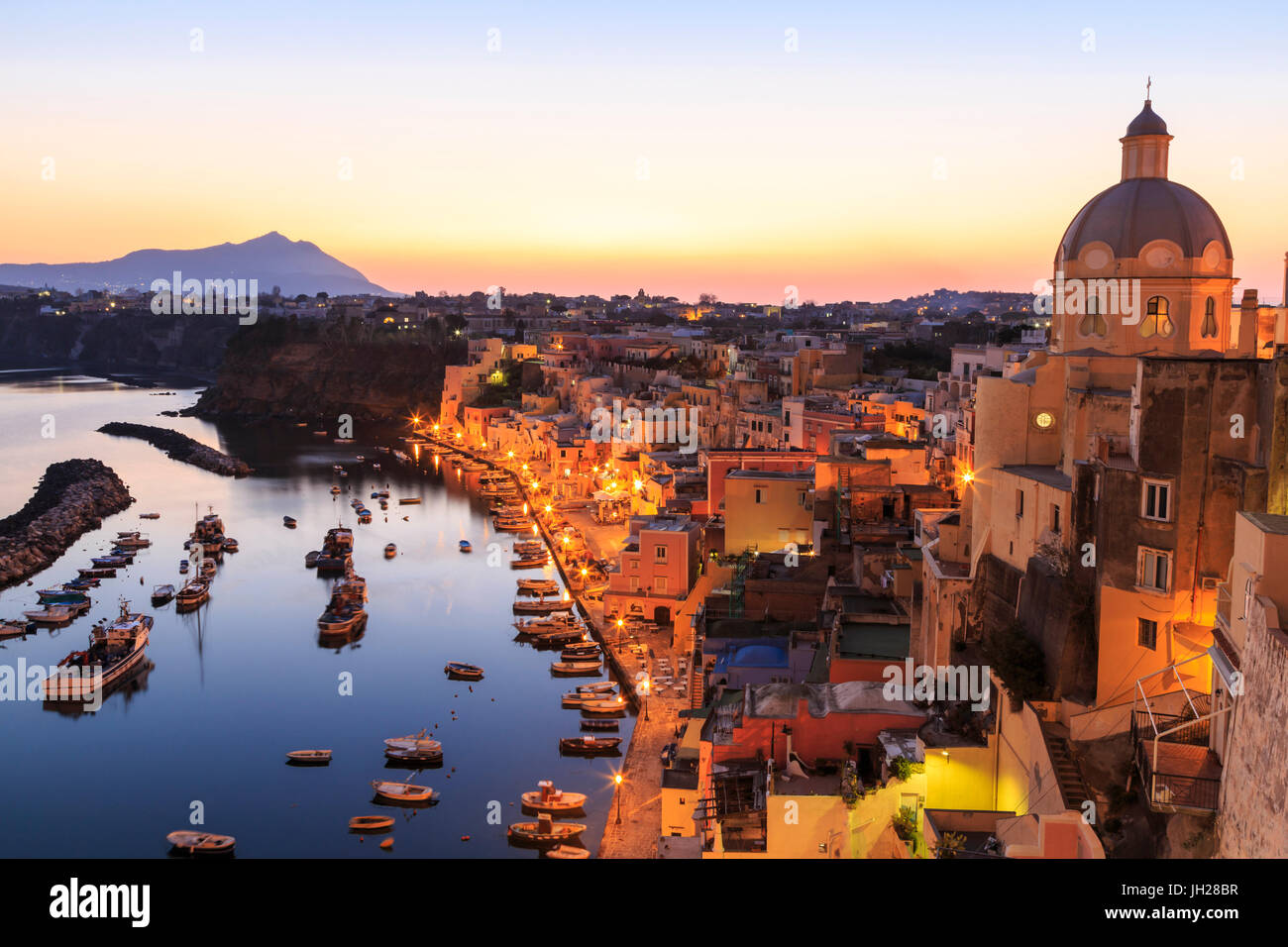 Marina Corricella, blu ora dopo il tramonto, villaggio di pescatori, case colorate, barche e chiesa, Procida, Baia di Napoli, Italia Foto Stock