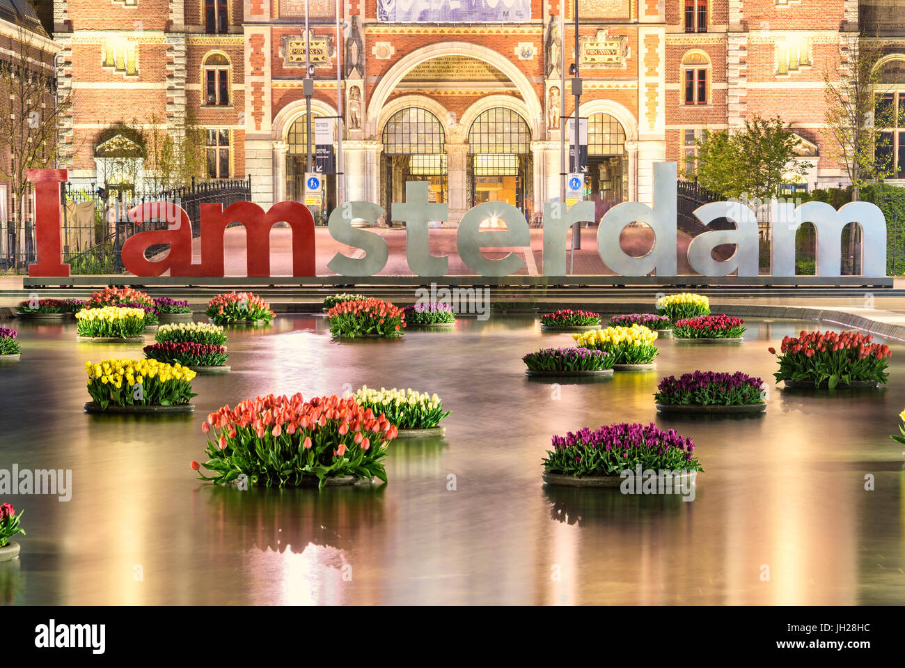 Il National Rijksmuseum incorniciato da vasi di fiori galleggianti in acqua, Amsterdam, Olanda, Paesi Bassi, Europa Foto Stock