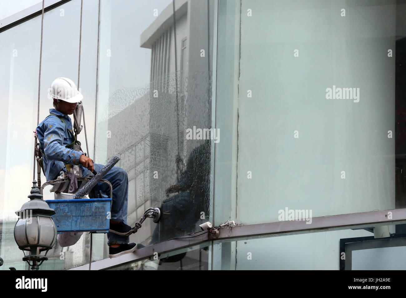 Uomo di pulizia windows office. Il Vietnam. Foto Stock