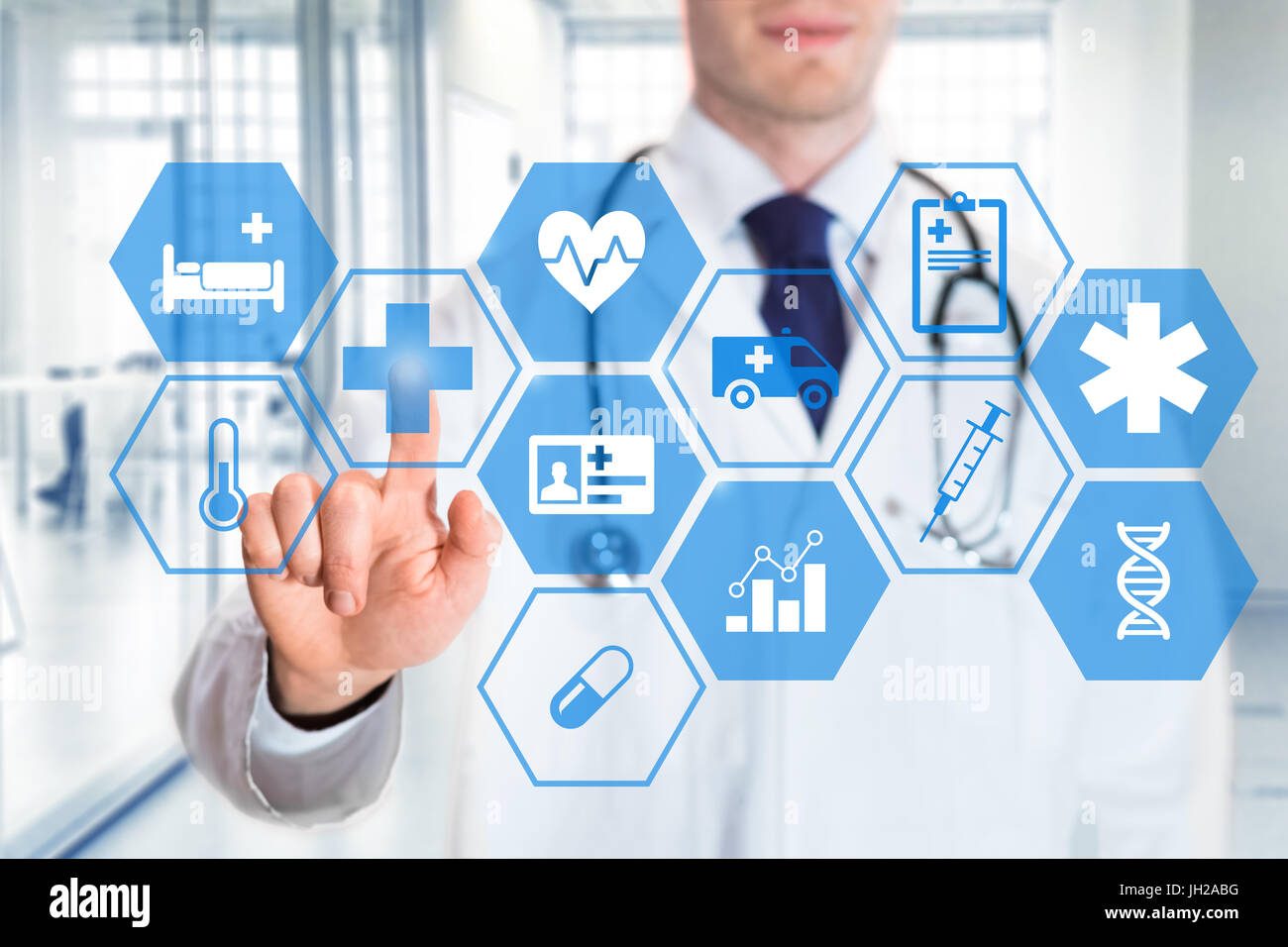 Medico toccando le icone dei servizi di cura per la salute su un display digitale, con ospedale di fondo interna Foto Stock