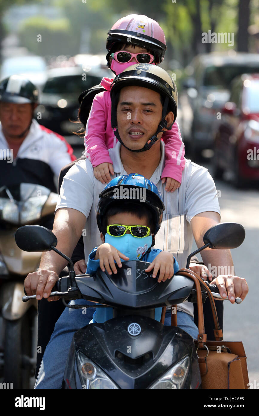 Famiglia vietnamita in sella a una motocicletta sulla strada di Saigon. Il Vietnam. Foto Stock