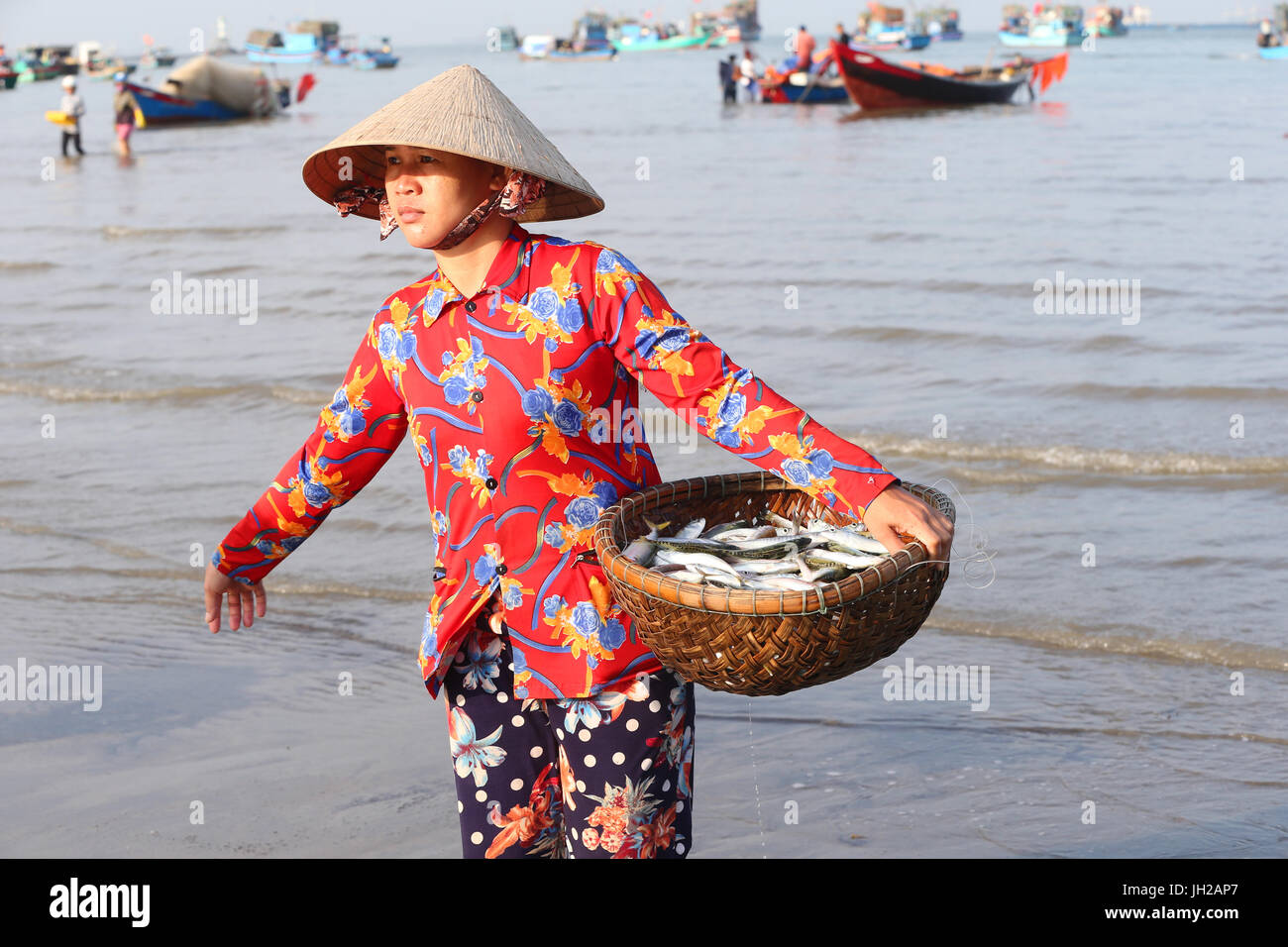 Vung Tau beach. Barche da pesca. Donna ordinamento di pesca di cattura. Il Vietnam. Foto Stock