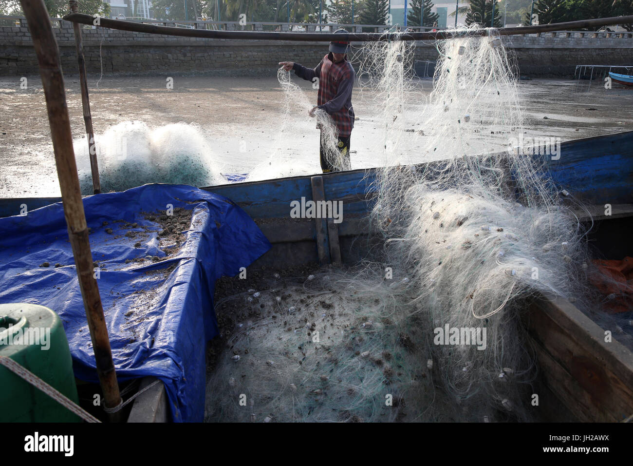 Fisherman preparare un netto sulla spiaggia. Il Vietnam. Foto Stock