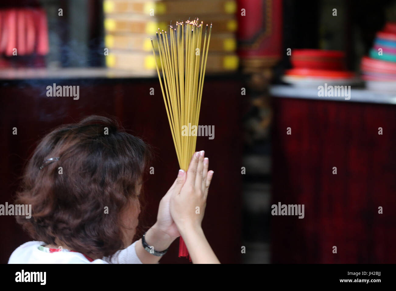Il tempio taoista. Phuoc un Hoi Quan Pagoda. Adoratore buddista. La masterizzazione di bastoncini di incenso. Ho Chi Minh City. Il Vietnam. Foto Stock