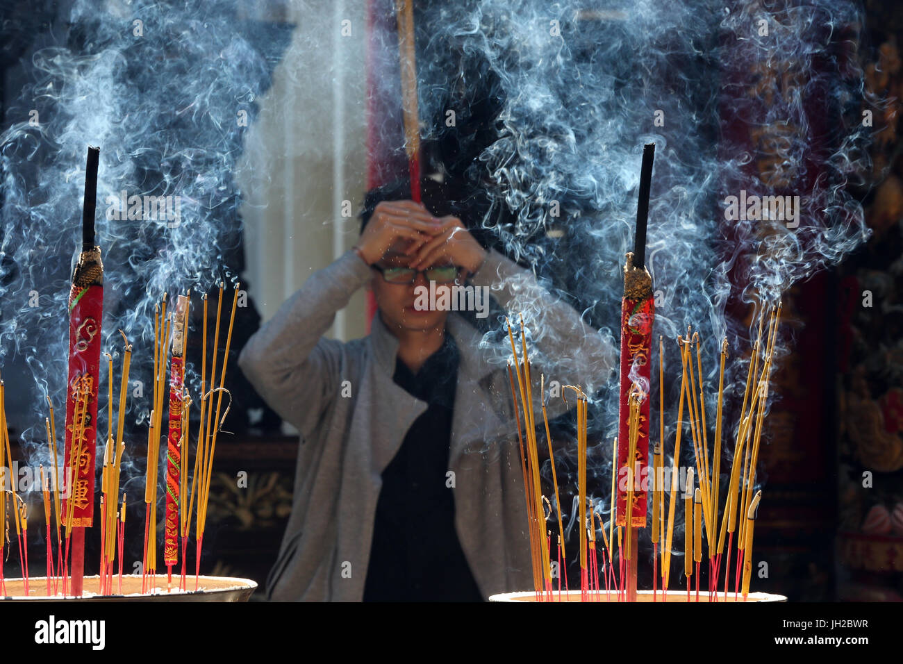 Tempiale di Taoist. Phuoc un Hoi Quan Pagoda. Bastoncini di incenso sul bastone di joss pot sono in fiamme e fumano uso per pagare rispetto al Buddha. Adoratore di buddista Foto Stock