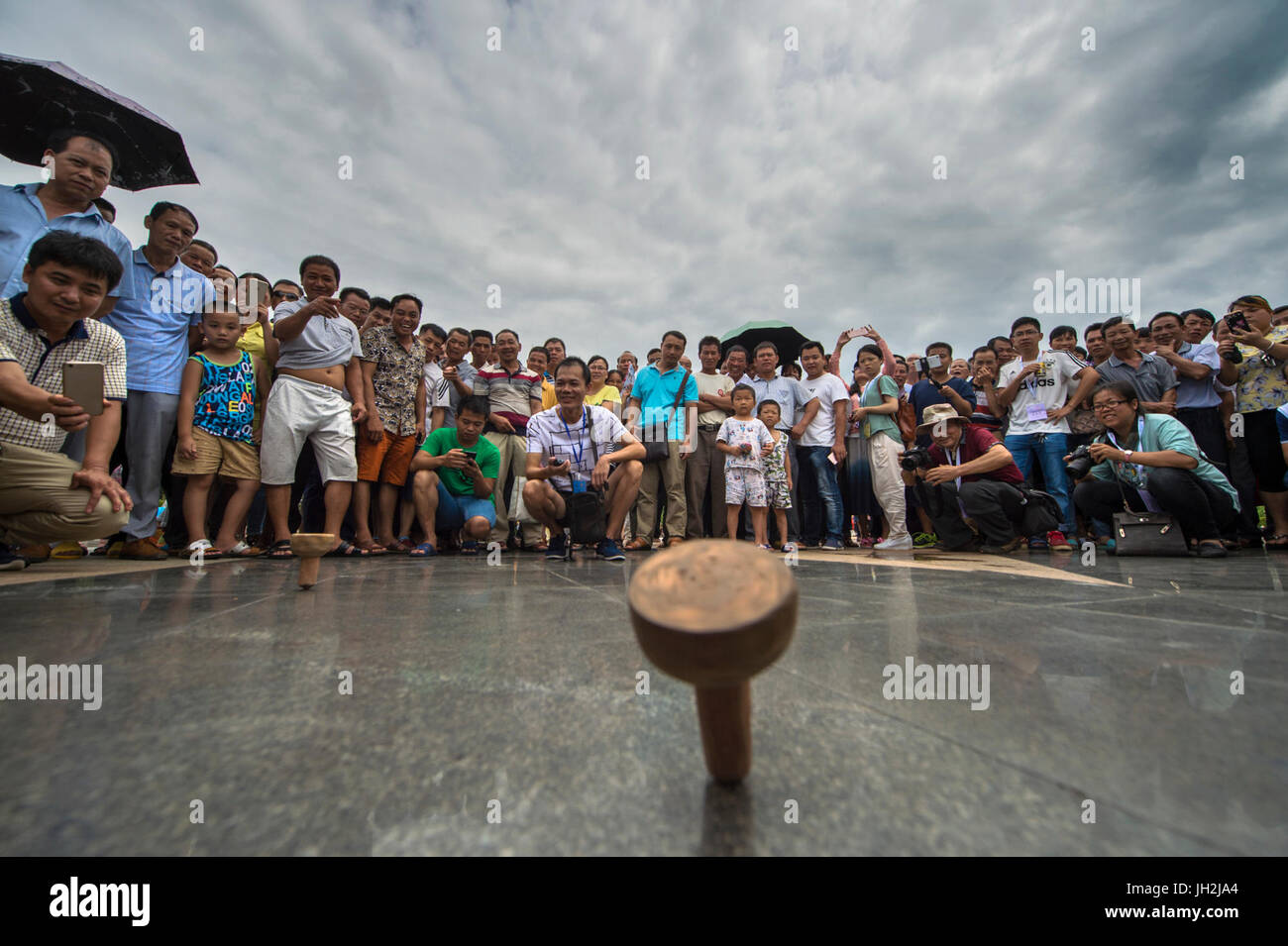 Baise, della Cina di Guangxi Zhuang Regione autonoma. 12 Luglio, 2017. La gente guarda un top spining gioco in Tiandong County, a sud-ovest della Cina di Guangxi Zhuang Regione autonoma, luglio 12, 2017. Un festival della musica folk di mango con la cultura si è svolta nella contea di Tiandong mercoledì. Diverse attività come top spining, gare di maiale, indumento show e concorsi di mango ha attirato molte persone. Credito: Xie Peixia/Xinhua/Alamy Live News Foto Stock