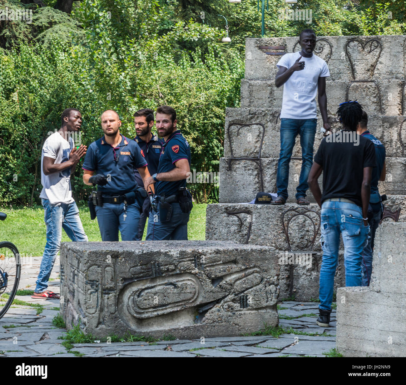 Milano, Italia. 12 Luglio, 2017. Un uomo che sembra essere un migrante supplica alla polizia a Milano il Parco Sempione. L'Italia è la patria di molti profughi che fuggono dalla guerra e dalla povertà in Africa del Nord e Medio Oriente Credito: Alexandre Rotenberg/Alamy Live News Foto Stock